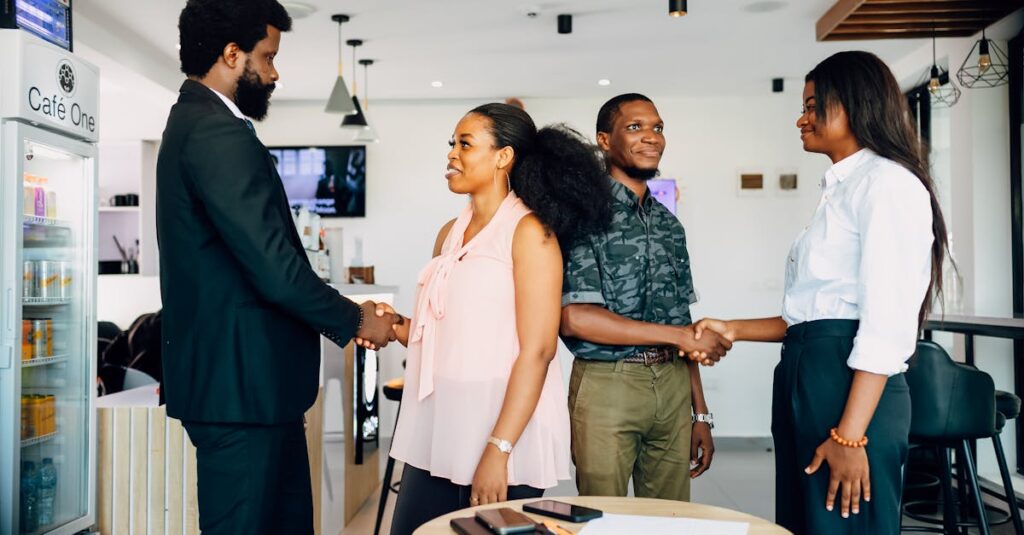 Business meeting with handshake in a modern Lagos cafe, showcasing collaboration and teamwork.